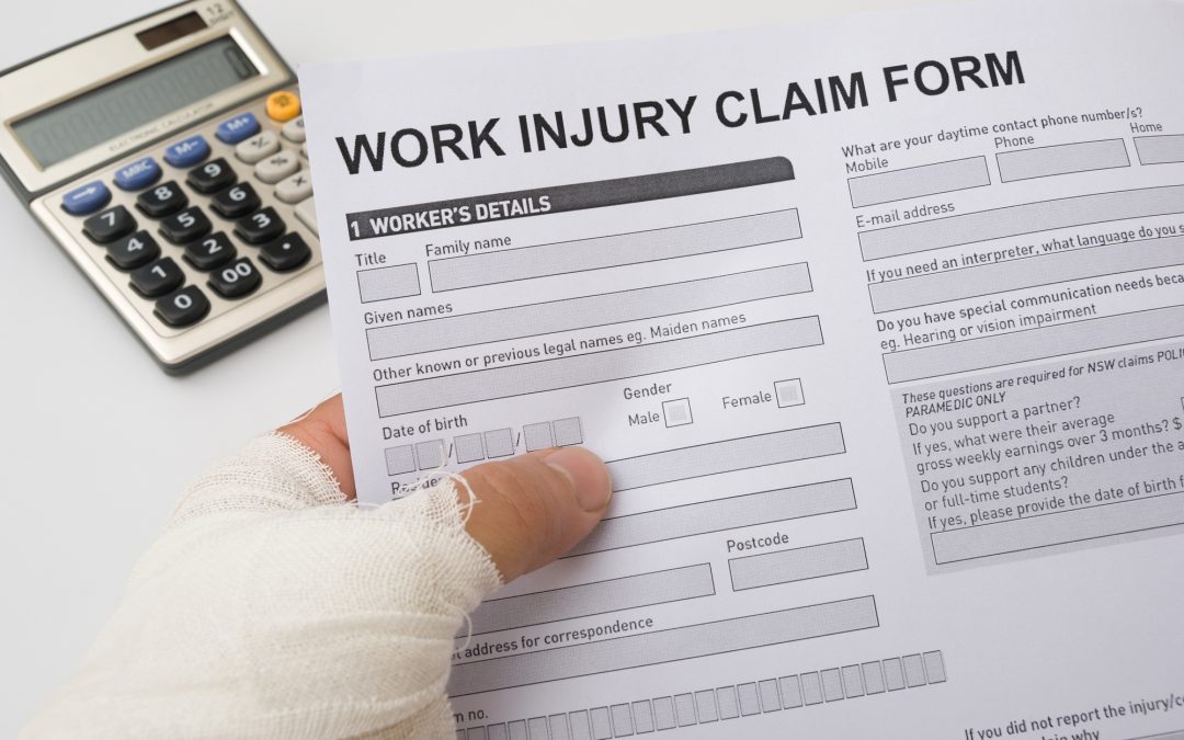 hurted hand holding a work injury claim form